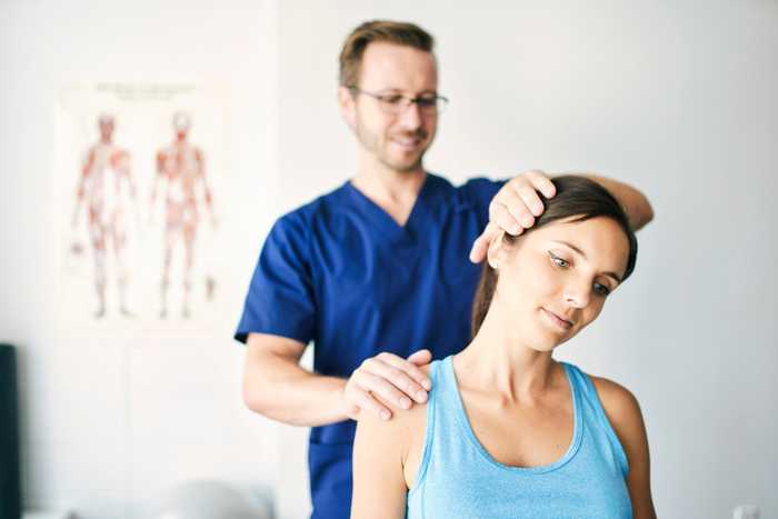 a doctor examining a woman's shoulder with a stethoscope